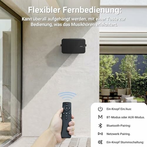 Person steuert Lautsprecher im Freien mit Fernbedienung